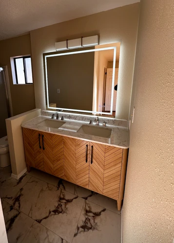 a truly custom vanity in bamboo, with quartz top and lighted mirror