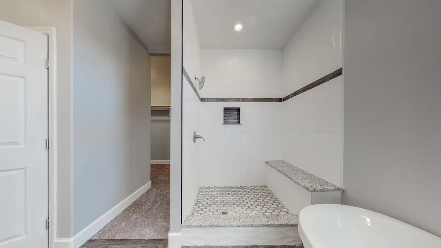a large Walk-in shower with tile walls and built-in bench