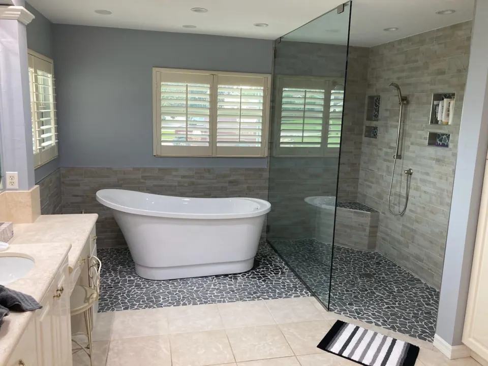 Freestanding tub beside open tiled shower