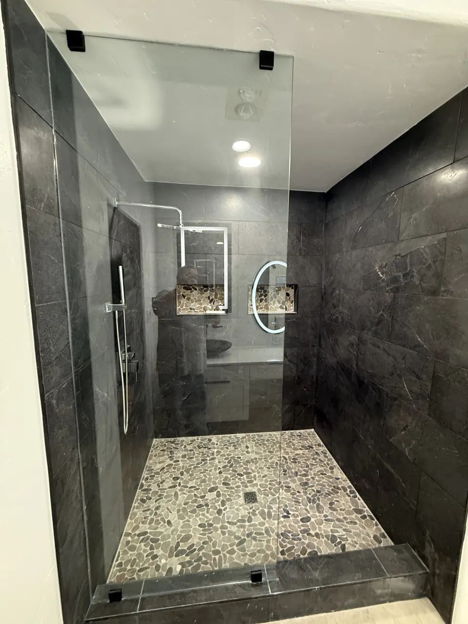 Gray tile shower with pebble floor