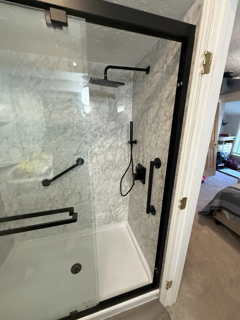 Tile shower with black grab bars